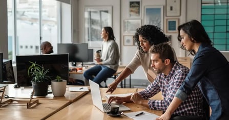 Meeting planners in front of laptop in an office working on procurement